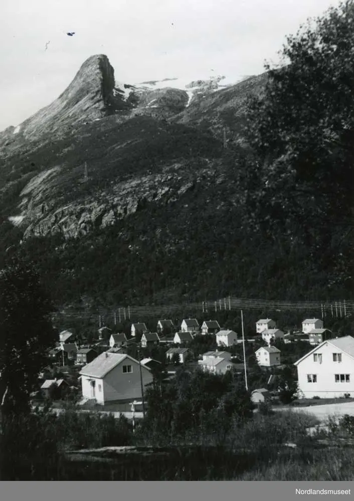 Glomfjord. Fjellet Sfinxen i bakgrunnen. Hus. Strømmaster ...