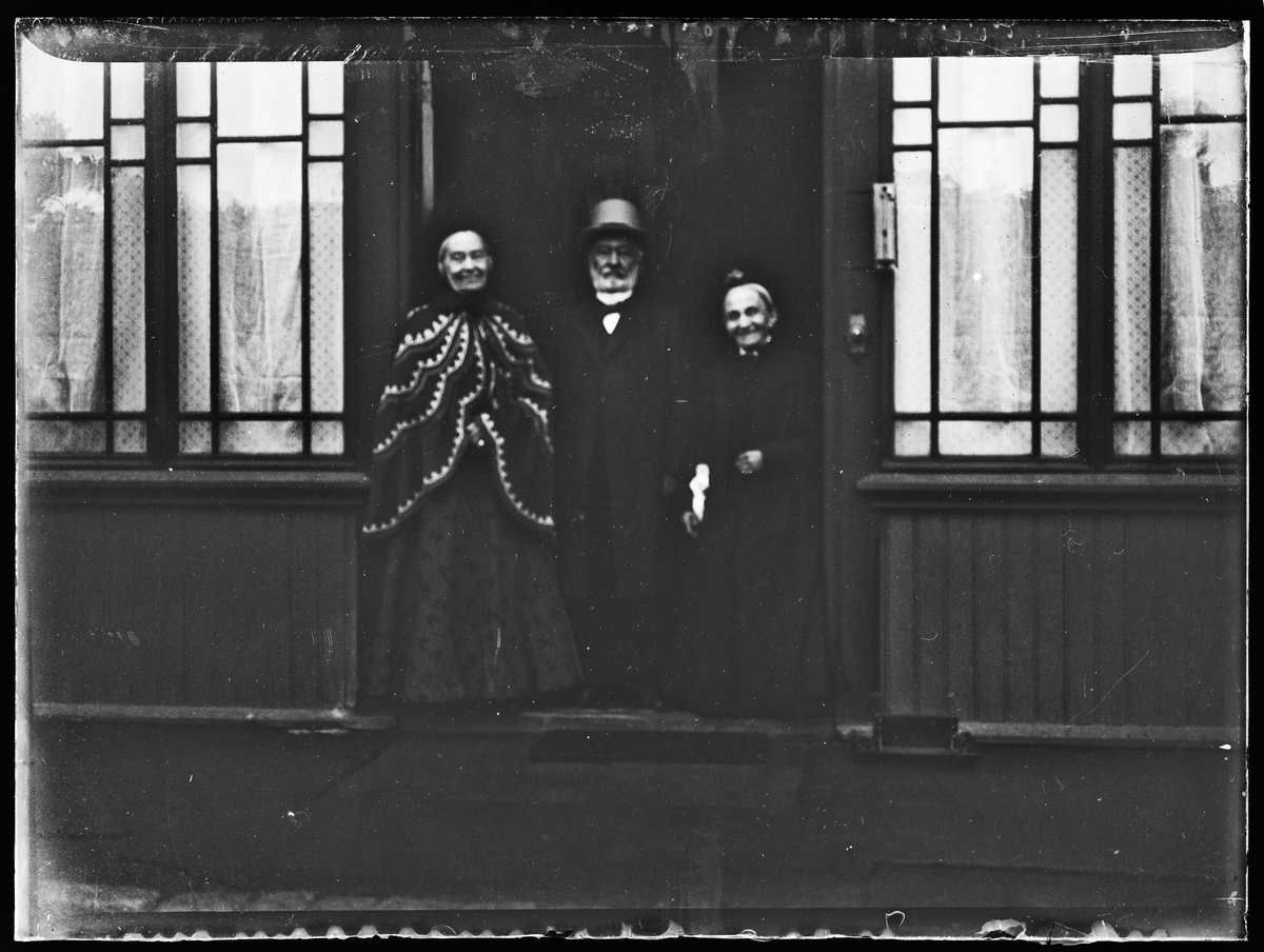 Haaken Christian Mathiesen og to damer står i en døråpning.