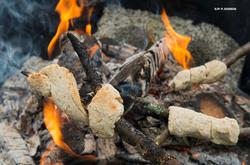 Steking av pinnebrød over åpen varme.  Pinnebrød steikes av 