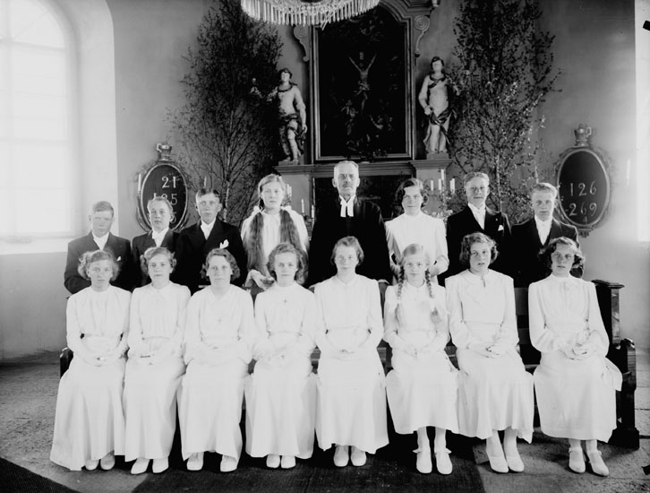 15 konfirmander, 10 flickor, 5 pojkar och kyrkoherde Erhard Morén.
Interiör av Vintrosa kyrka.
