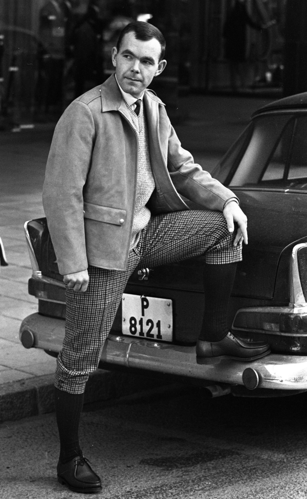 Höstmodet, 16 september 1965

Höstens herrmode visas hos Bengt Nordins modebutik. I år skall det vara en blandning av amerikansk gangster och engelsk gentleman. Här visar modellen sig i mockajacka. slipover, rutiga tweedknickers, knästrumpor och svarta promenadskor.Han stöder vänstar foten mot bakre kofångaren på en bil med registreringsnummer P 8121.