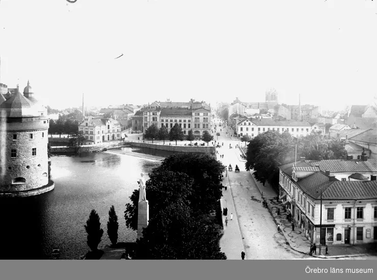 Stadsvy, Drottninggatan söderut, Örebro Slott, Storgatan och Drottninggatan, Nikolaikyrkan, byggnader och bostadshus.
Reproduktion efter en bild tagen före 1926.