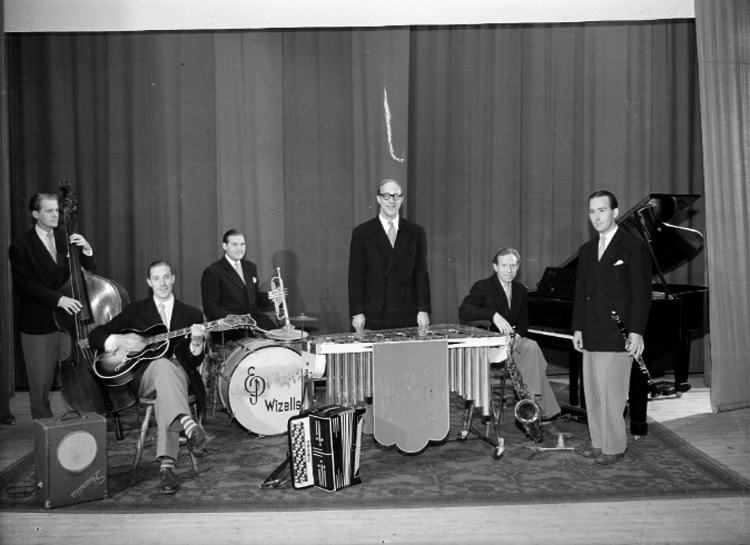 Wizells orkester, sex män med musikinstrument.