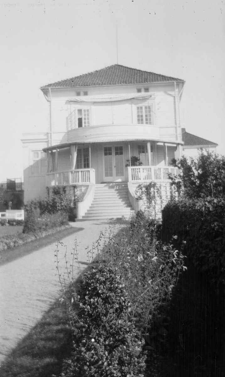 Halvsirkelformet veranda på hovedhusets ene kortside på Linderud Gård, med trapp opp fra hagen.