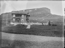 Et toetasjes hus med inngjerdet hage. Huset er bygget i et f