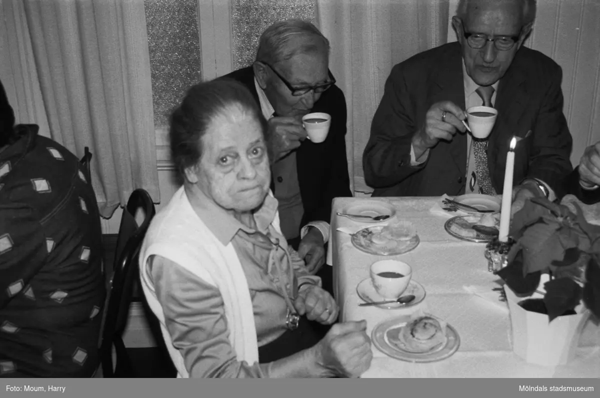 Greggered kapell i Lindome, år 1983. En äldre kvinna och två äldre män dricker kyrkkaffe efter gudstjänsten.

För mer information om bilden se under tilläggsinformation.