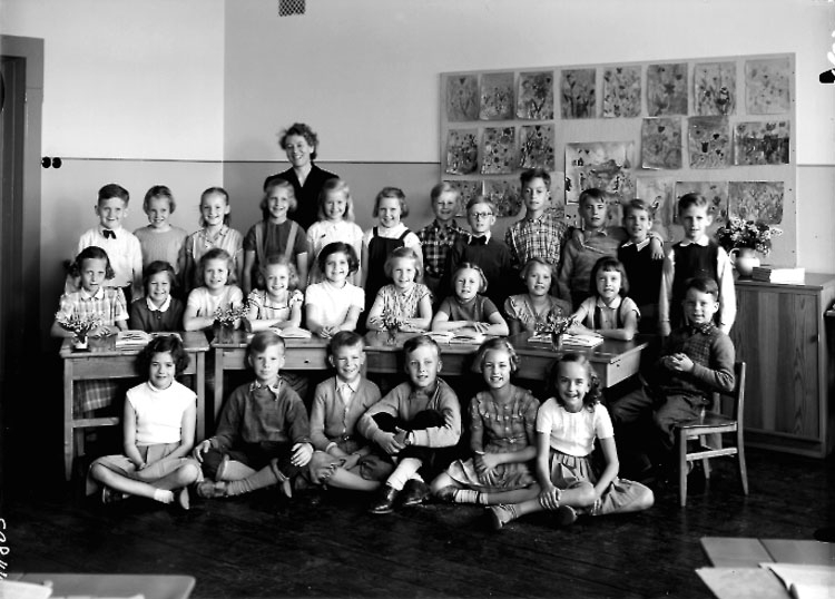 Olaus Petrikskolan, klassrumsinteriör, 28 skolbarn med lärarinna fru Maja Mollbeck.
Klass 2b, sal 18.
