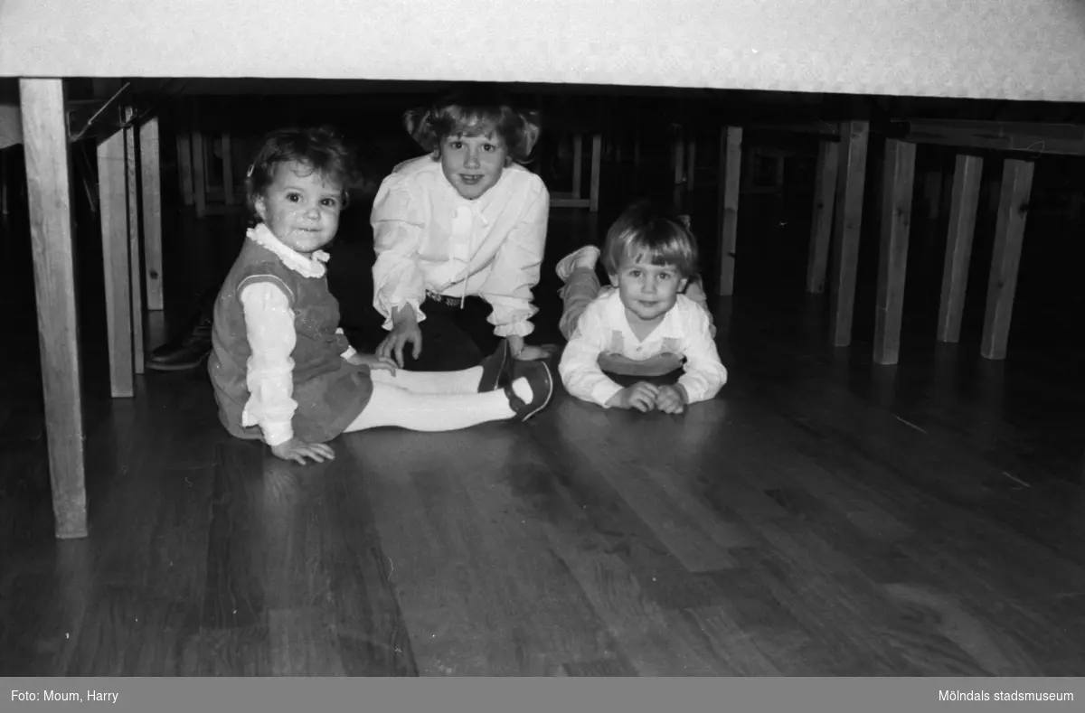 Lindome hembygdsgilles julgille på Hällesåkersgården i Lindome, år 1984. Tre barn under ett bord.

För mer information om bilden se under tilläggsinformation.