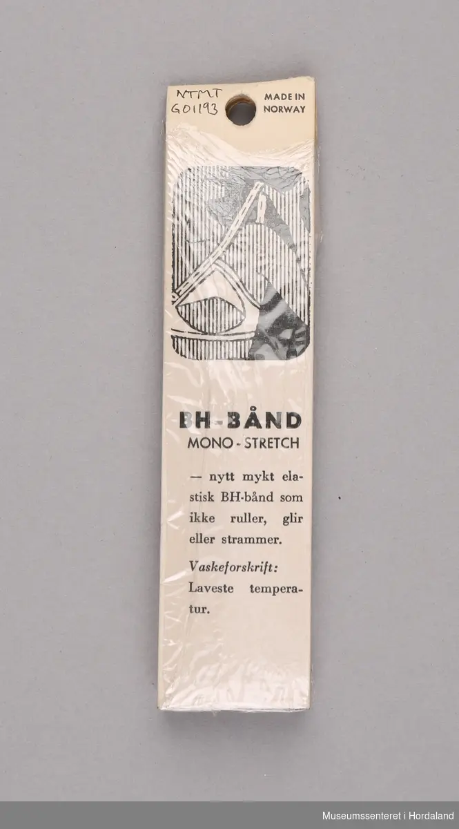Mørkeblått BH-bånd i lycra, pakka i plast- og pappemballasje. Produsert av Trengereid Fabrikker: "nytt mykt elastisk BH-bånd som ikke ruller, glir eller strammer".