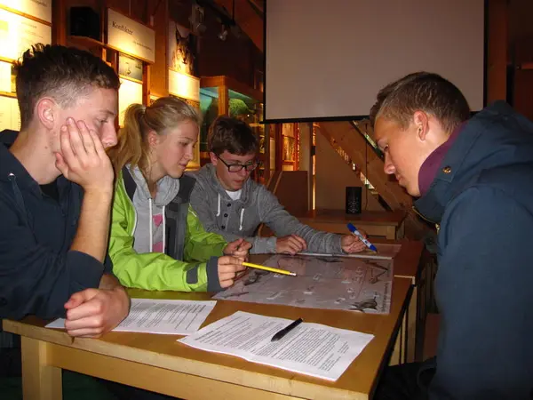 Foto av elever som løser oppgaver inne på besøkssenteret