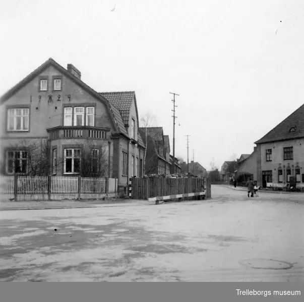 2:a Världskriget 1939-, vägspärrar på Trelleborgs gator. Dessa som vara byggda av grova stockar och fyllda med stora stena. De avsåg att spärra alla tillfartsvägar till hamnen. Öppningen mellan kistan kunde hastigt avstängas med järnbalkar. Ansågs mot krigets slut som betydelselösa och togs bort efter hand 1944-45, 14075 foto från söder mot hörnet av kvarteret Ekaren.