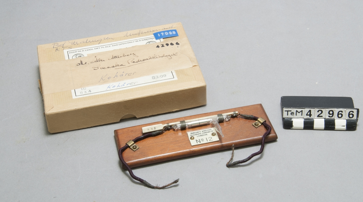 Detektor monterad på träplatta, i kartong. Märkt: Marconi`s wireless telegraph company Ltd London, Nr 12.