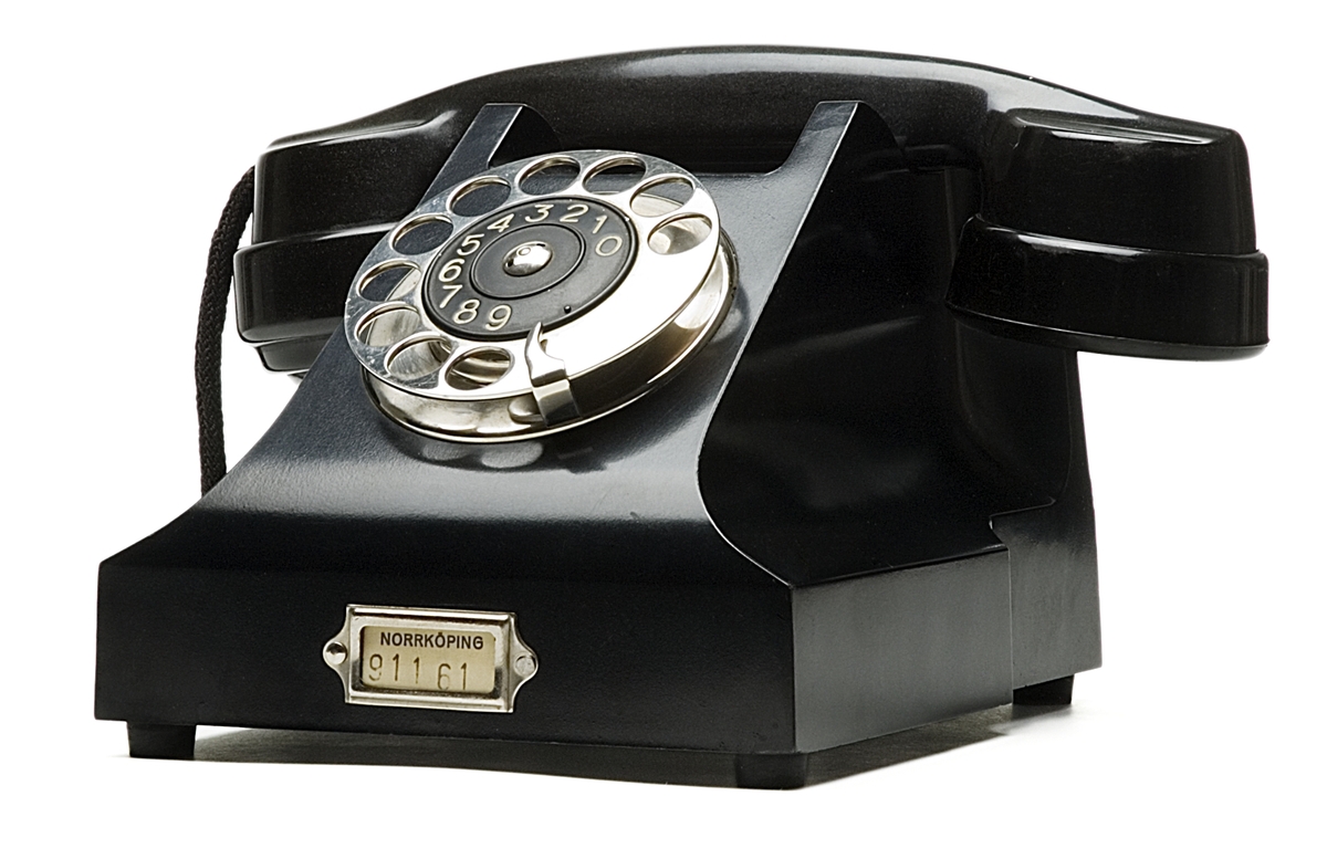 Telefonapparat BC 330, ändstationsapparat för AT-system. Bordapparat modell m33 av svart bakelit med fingerskiva av förnicklad mässing.