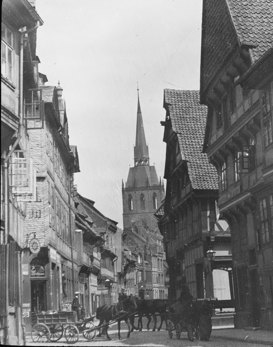 Skioptikonbild med motiv från gata i Hildesheim. I bakgrunden syns St. Andreas Kirche.
Bilden har förvarats i kartong märkt: Hildesheim. Serien E.