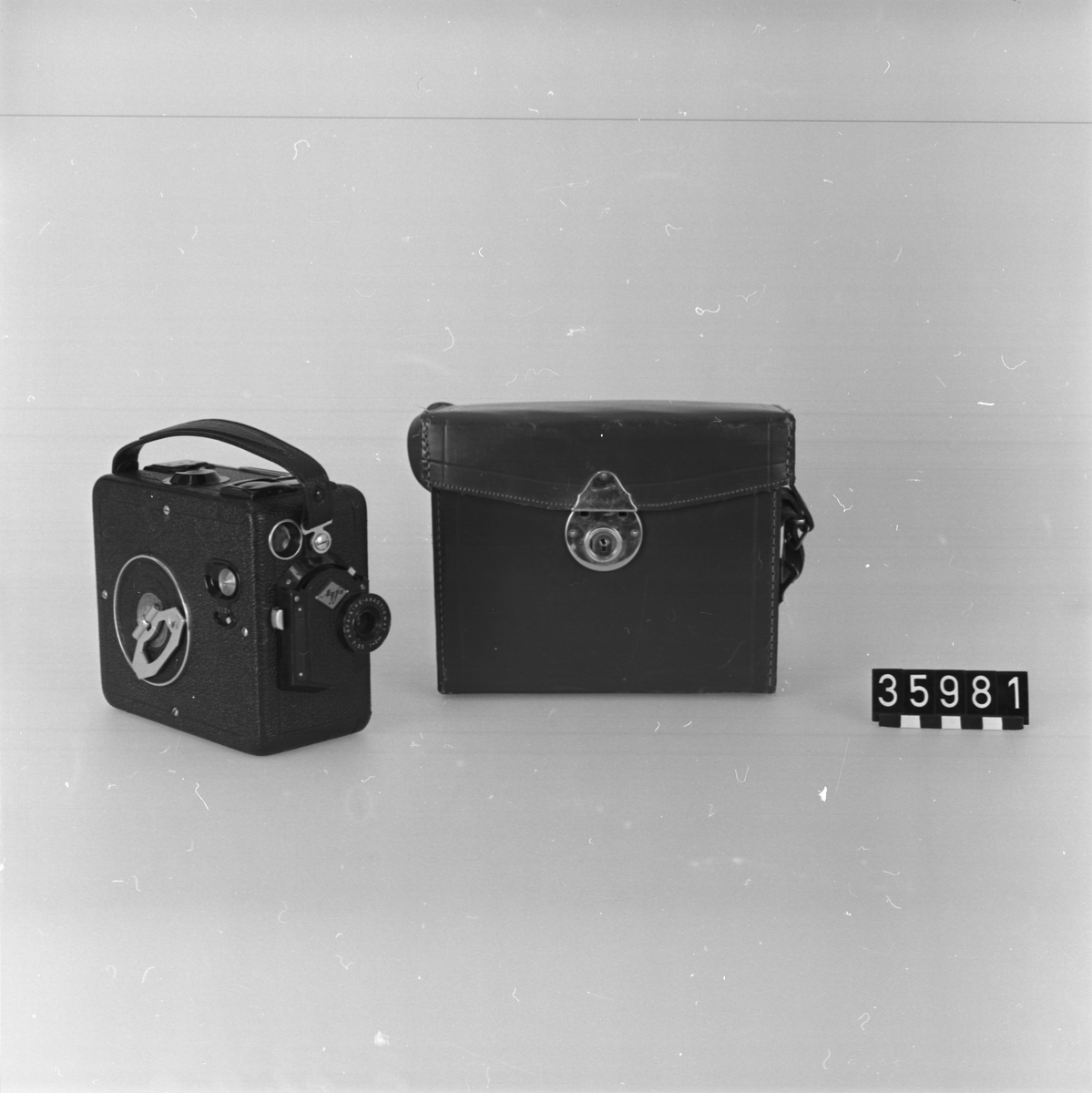 Smalfilmskamera, för 16 mm film. Läderklädd aluminiumplåt i läderväska med bärhandtag. Objektiv: Agfa-Kine Anastigmat F.3.5, brännvidd: 20 mm, fixfocus, grovinställning för skärpeområden 1-3 meter resp. 2-oändligt. Låsbar utlösare. Filmräkneskala 1-12. Kassettladdning.
Tillbehör: Tom filmkassett Agfa Isopan medföljer.