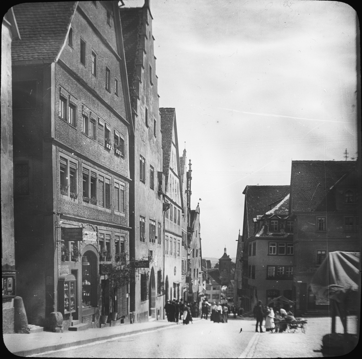 Skioptikonbild med motiv från Rothenburg ob der Tauber.
Bilden har förvarats i kartong märkt: Vårresan 1910. Rothenburg XXIX.. Text på bild: "Markt".