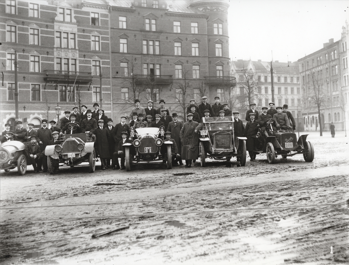 Elever vid Eric Lundviks körskola, samlade kring automobiler på Karlaplan, omkring 1915-1920.