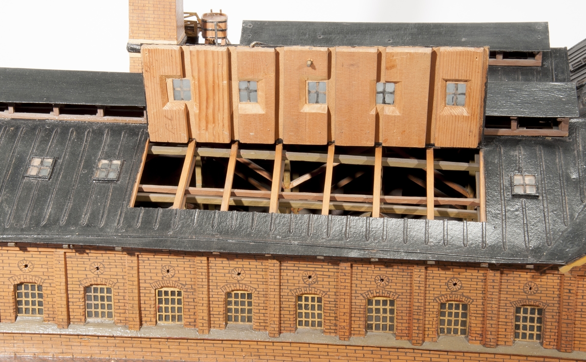 Modell av kopparextraktionsverk av trä och glas. Föremålet föreställer en fabriksbyggnad med hög skorsten inkl. rökmoln. Ett lätt ånglok med fyra malmvagnar ingår.
Tillbehör: Glasmonter.