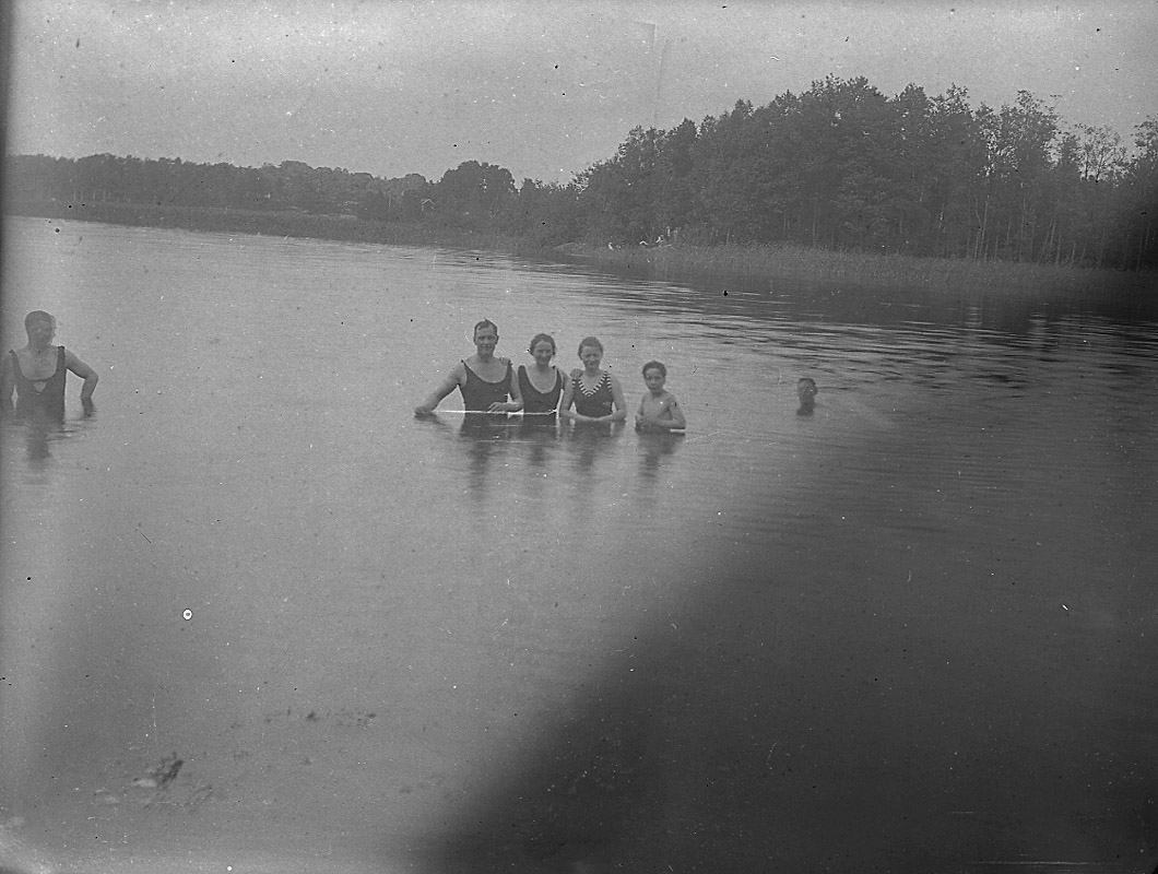Badplats, sex personer i vattnet.