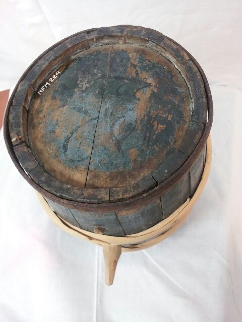 Tønneforma, lita kagge. Lagga. Buler ut på midten. Jarnband øvst og nedst. To band i tre på midten. Eit lite og eit litt større hol på eine staven. I hola er sett tre-tappar. Band og tappar i tre er sett på i nyare tid. Botnplate i begge kortendar.