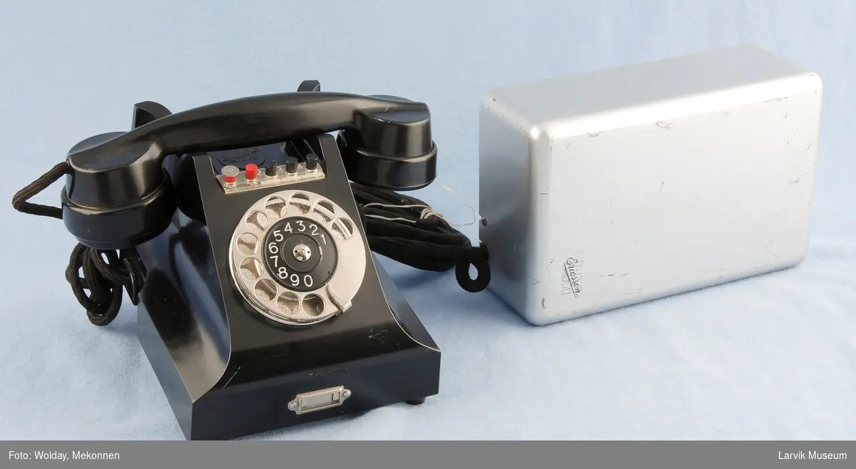 Form: Vanlig telefon med rektangulær kassen til rele. Knapper form valg av linje over tallskive. tallskive i metall
