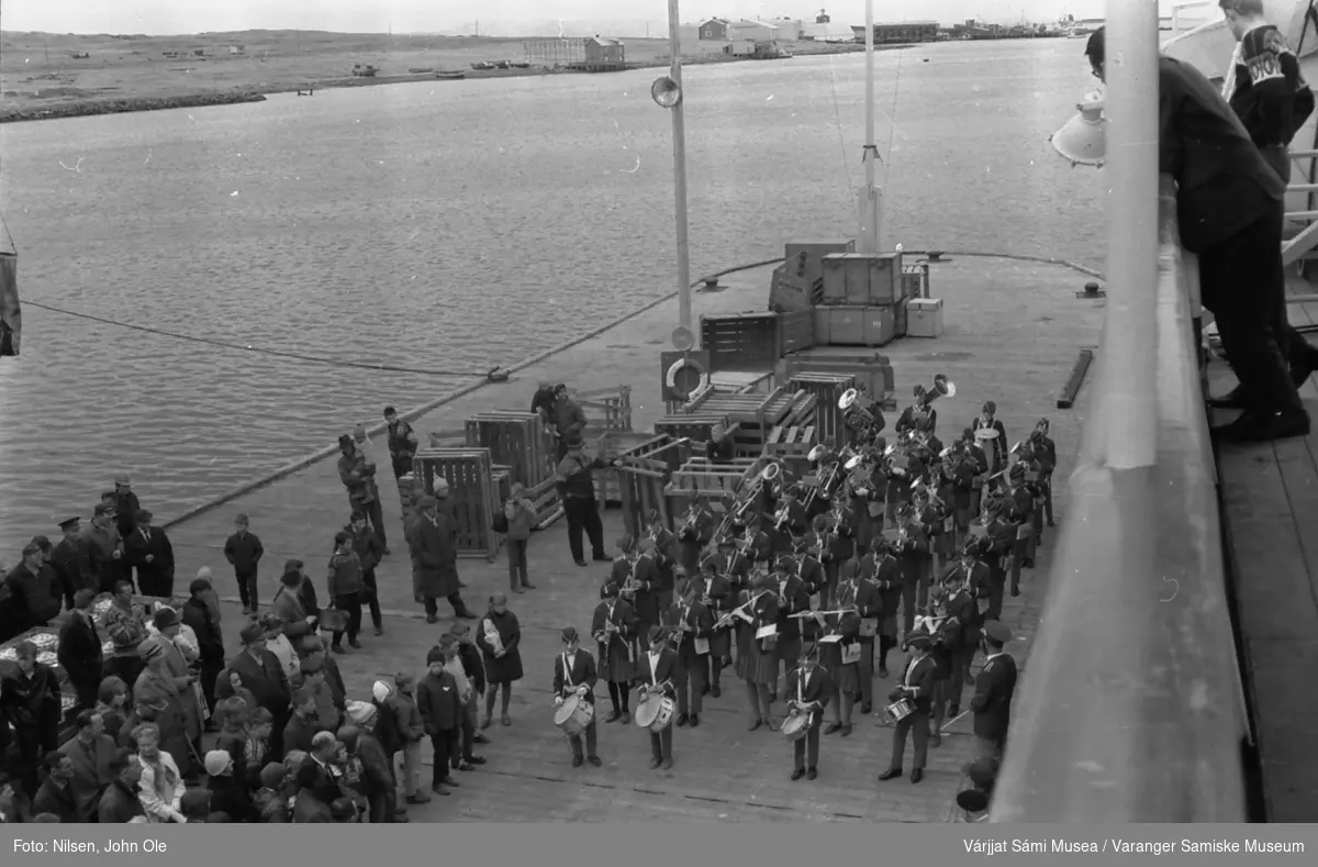 Hurtigruteskipet Ragnvald Jarl ligger i havn i Vadsø. Musikere spiller på kaia. 7. juni 1966.
