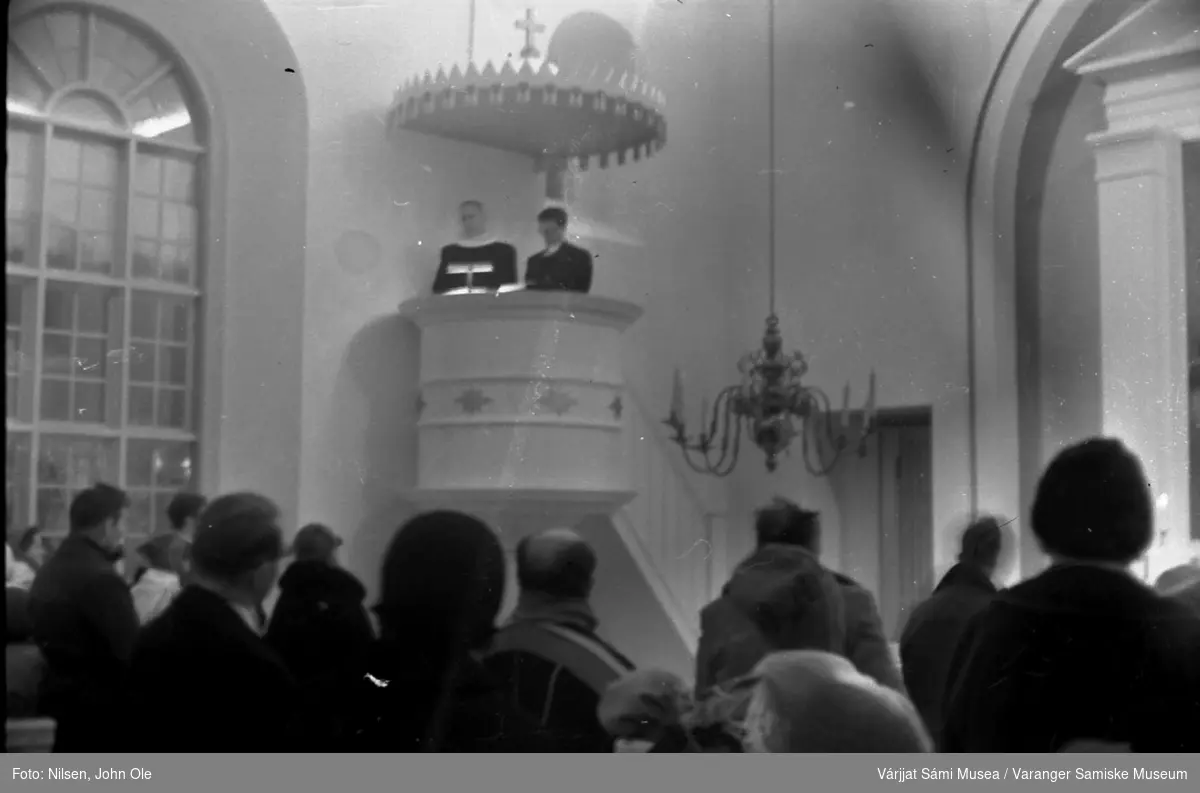 Gudstjeneste, sannsynligvis i en kirke på finsk side. Presten og kirketolken står på prekestolen. Presten er Erik Schytte Blix. Ukjent sted høsten 1966.