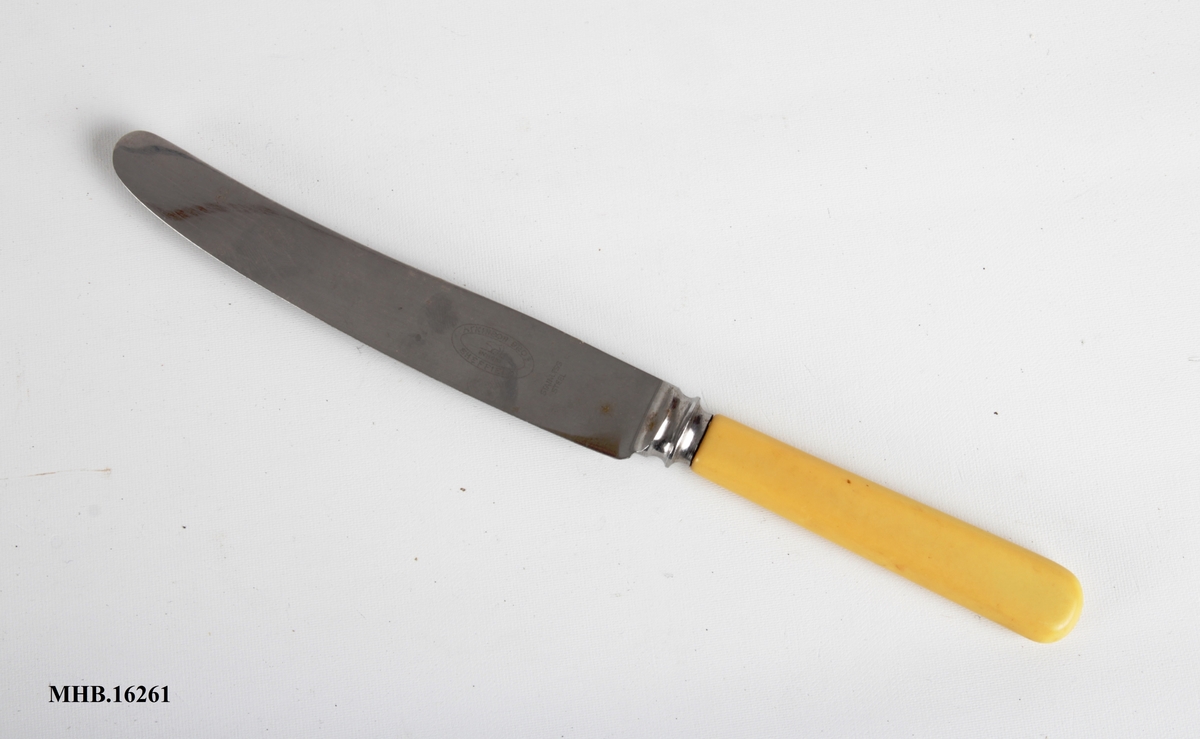 Bordkniv med avrundet blad og hvitt plastskaft.