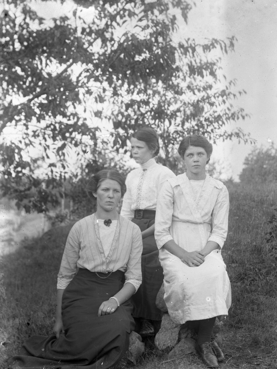 Tre kvinnor fotograferade utomhus. Kvinnorna är fotografens systrar (från vänster i bild) Anna, Signe och Lydia Siken.