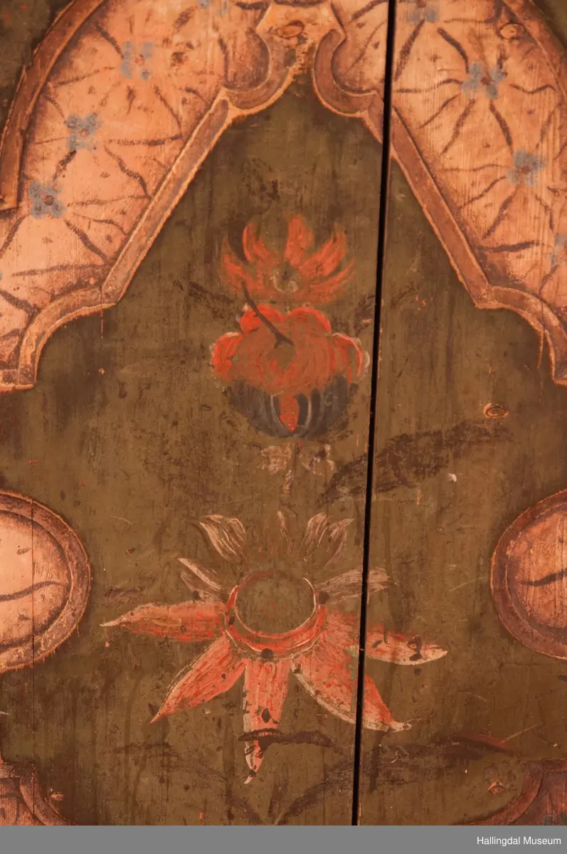 Marmorert toppstykke over felt med fem fyllinger.  Feltet grønnmalt med røde og hvite blomster.  Fyllingene, hvit bunn, sortmalte bokstaver og tall:  Anno 1796 H. Sata.  Overskapet har to hyller med lister og en smal hylle med profilert kant.  Bakveggen hvitmalt med rester etter mørkere undermaling, sideveggene marmorert.  Underskapet tredelt, fremspingende midtparti som er dør.  Fyllinger på de tre delene.  Grønn bunnfarge.  Slitt rosemaling, hvitt og rosa.  Profilert gulvlist.  Nøkkelhull med beslag og defekt lås av jern.  En hylle innvendig.