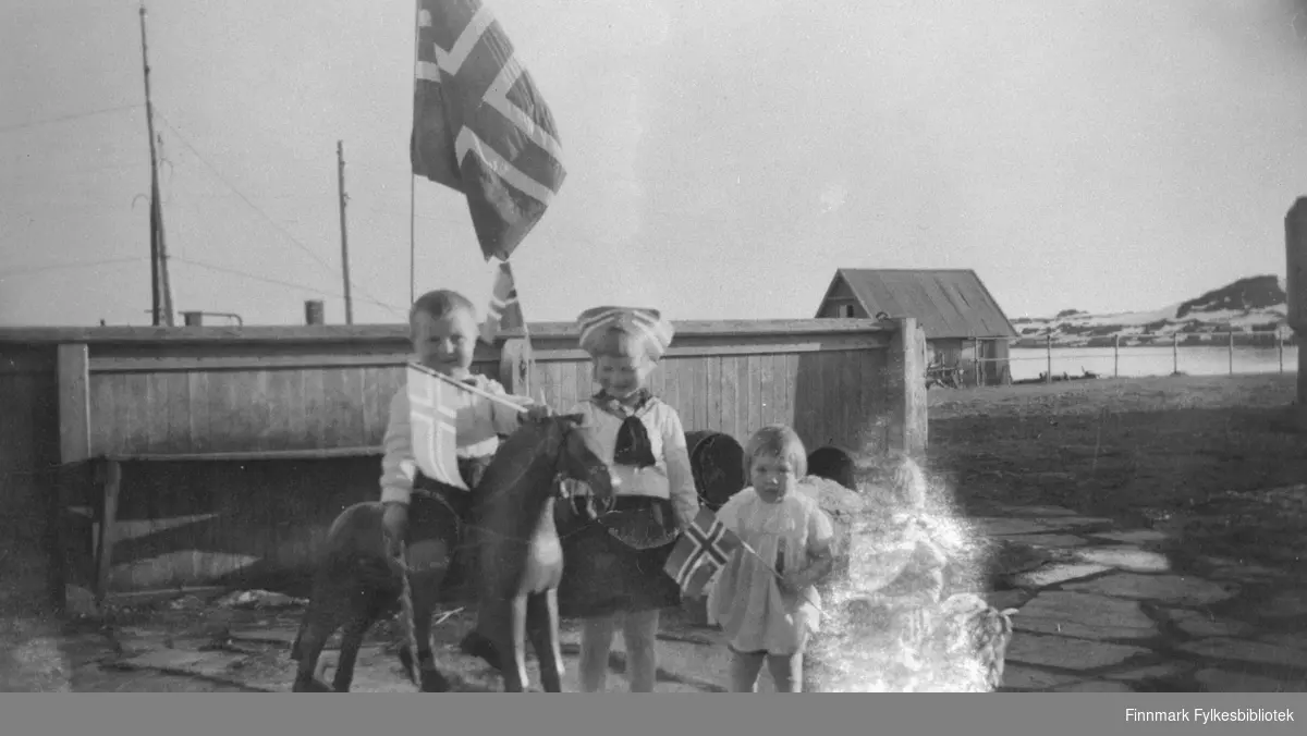 Barn i 17.mai stemning med norske flagg.