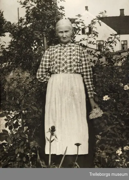 Alberts farmor Metta Mårtensson född år 1849-01-05 nr 8 Maglarp.Gift med Jöns Persson född 1843-10-25 i Skegrie.Kortet är tagit i deras hus trädgård bakom Ehnevids hus.