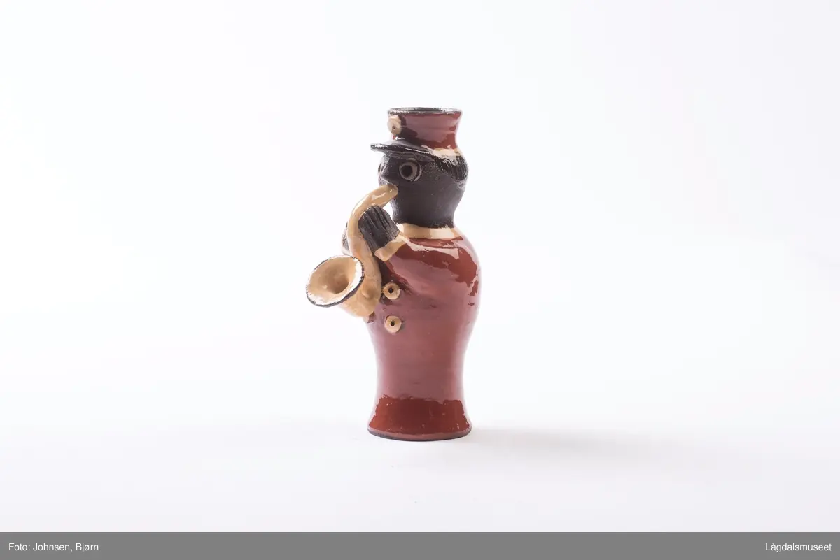 Dekoren på lysestaken utgjør uniformen til musikanten. Utforelsen er en musikant som spiller saksofon.