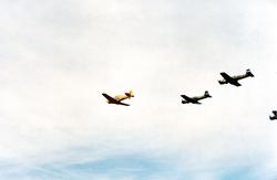 Fire fly i formasjon under et flystevne. T-6 Harvard og Yak-