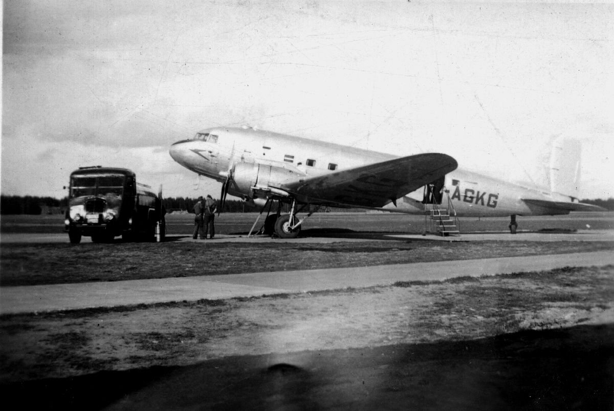 Lufthavn/Flyplass. Et fly, Douglas DC3 Dakota, parkert. En tankbil og ...