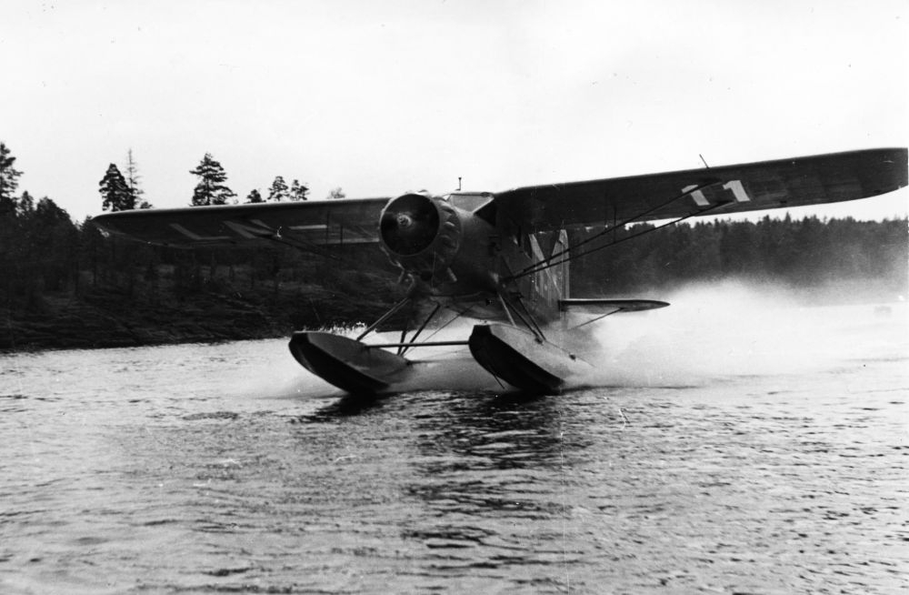 Landskap. Et sjøfly, LN-11, av typen C5 Polar fra Widerøe, iferd med å lette fra et vann.