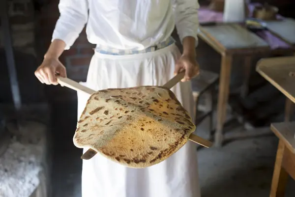 Kvinne viser frem ferdig stekt lefse