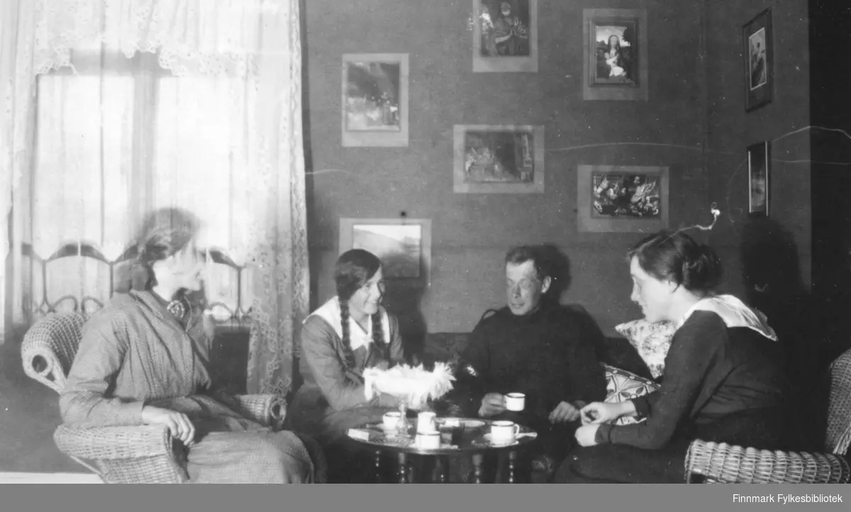 "Fredenslund mai 1917" lyder teksten i albumet. På bildet ser vi fire ungdommer, tre damer og en mann rundt et bord. Mannen med kaffekoppen på bildet er Hans Julius Gabrielsen. Den unge damen til høyre på bildet er en av hans søstre. Damen til venstre sitter i en kurvstol, hun har på seg en kjole med små prikker og belte i livet, og en brosje i halsen. I sofaen eller divanen sitter en jente med mørke lange fletter, hun er kledd i en kjole med stor, hvit krage. I høyre side av bilde sitter en annen ung kvinne og smiler, hun er kledd i en kjole med hvit krage og belte i livet. Håret er oppsatt i en knute bak. På bordet står det kaffekopper, et stettfat med det som ser ut som en heklet duk og til venstre på bordet ligger en eske, muligens sigaretter eller spillkort? På veggen henger bilder med bibelske motiv, ref. madonna med barnet øverst til høyre. Fredenslund var Lensmann Strands gård, og lå i Bonakas, Tana. Bonakas, nordsamisk: Bonjákas, er en jordbruksbygd beliggende på vestsiden av Tanaelva i Tana kommune omkring ti kilometer ovenfor Tanamunningen.