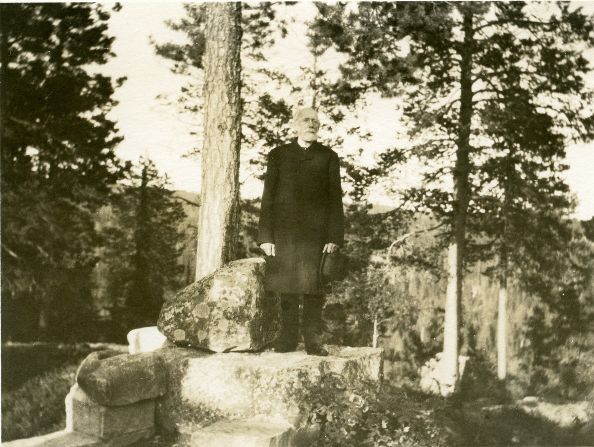 Prospektkort av Thomas Barth. Han står ved "prekestolen" på Vatneberget i Hedalen.