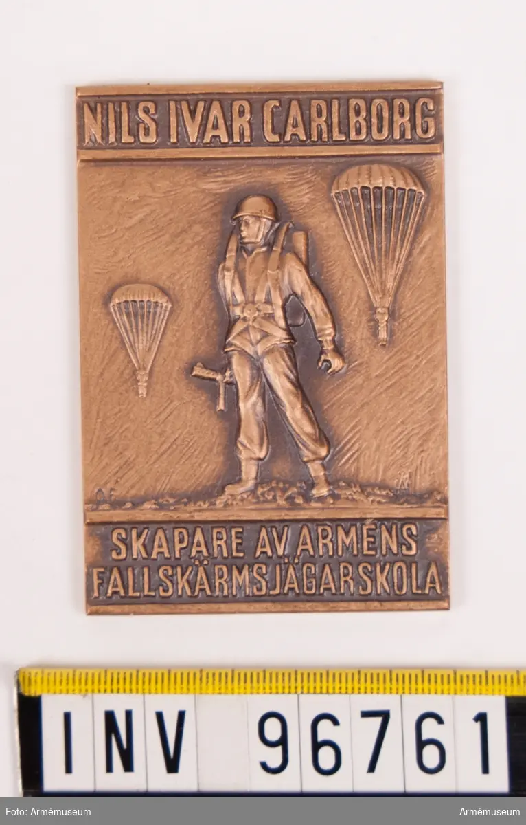 Plakett i brons för Nils Ivar Carlborg skapare av Arméns fallskärmsjägarskola.
Stans nr 56178.