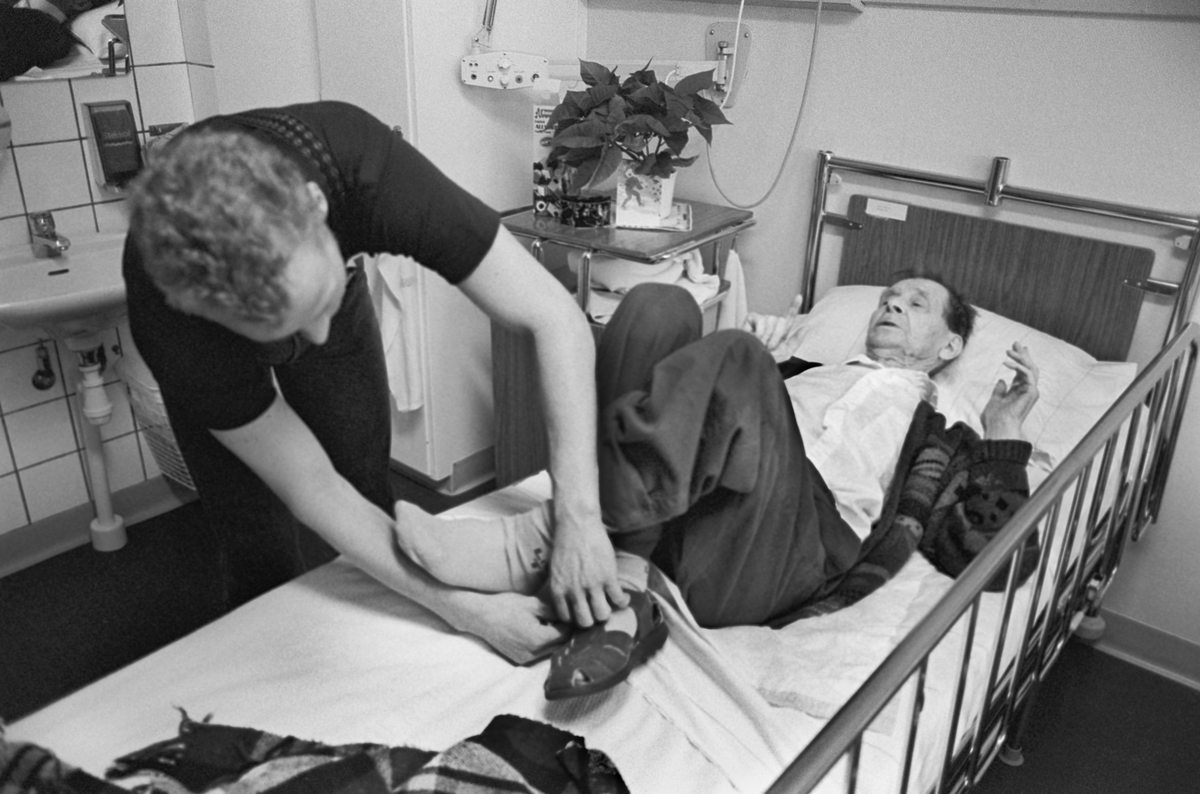 Äldre man får hjälp med sina skor, Tunåsens sjukhem, Uppsala 1992