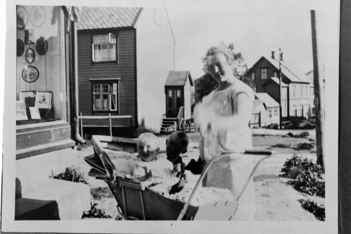 Kvinne med barnevogn. Til venstre Jenny Dahls fotoforretning.