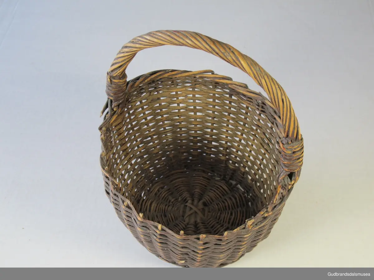 Liten kurv med hank. Sidene er flettet i kløvd kvist, bunnen i rund kvist (pil eller vier).