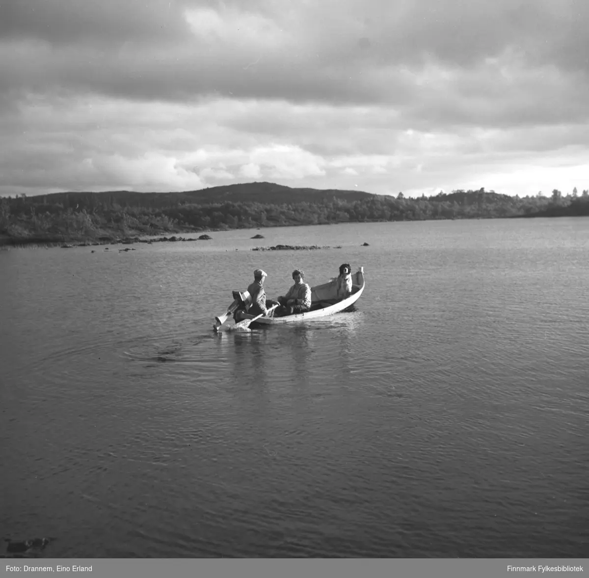 Uuno Lappalainen, Turid Karikoski og hunden Rexi i båt på en innsjø.