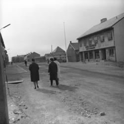 Tre ukjente damer spaserer bortover hovedgata i Vardø.