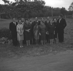 Flere personer i Karikoski-slekten poserer foran et jorde i 