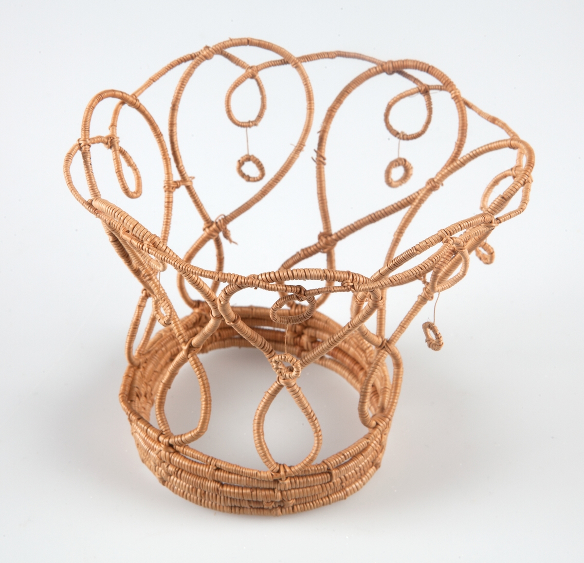 Brudkrona av bundna björkrötter. Dekorerad med små ringar. Tillverkad av Gertrud Nilsson.
