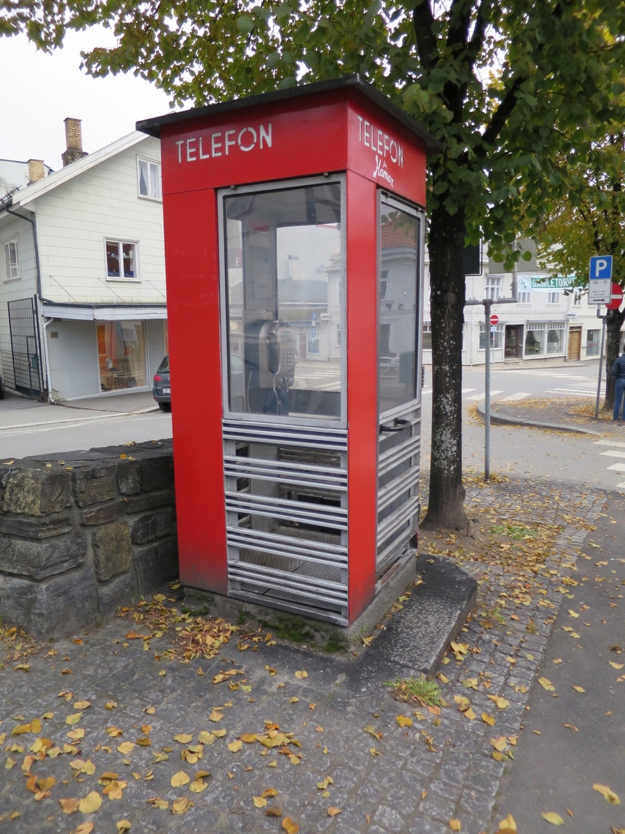 Telefonkiosken står på Gamletorvet i Gjøvik, og er en av de 100 vernede telefonkioskene i Norge. De røde telefonkioskene ble laget av hovedverkstedet til Telenor (Telegrafverket, Televerket). Målene er så å si uforandret. 
Vi har dessverre ikke hatt kapasitet til å gjøre grundige mål av hver enkelt kiosk som er vernet. 
Blant annet er vekten og høyden på døra endret fra tegningene til hovedverkstedet fra 1933.
Målene fra 1933 var:
Høyde 2500 mm + sokkel på ca 70 mm
Grunnflate 1000x1000 mm.
Vekt 850 kg.
Mange av oss har minner knyttet til den lille røde bygningen. Historien om telefonkiosken er på mange måter historien om oss.  Derfor ble 100 av de røde telefonkioskene rundt om i landet vernet i 1997. Dette er en av dem.