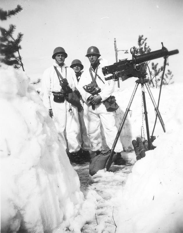 Soldater utført i vinter-kamuflasje på Midtskogen. De står ved siden av et maskingevær.