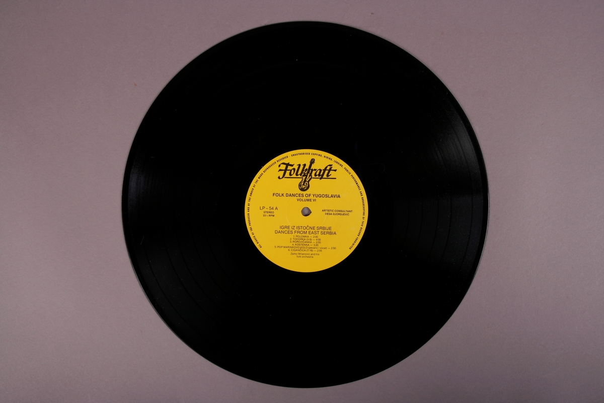 Grammofonplate i svart vinyl, papirlomme med påsatt tekstark, og et hefte med tekniske tegninger om dansetrinn.